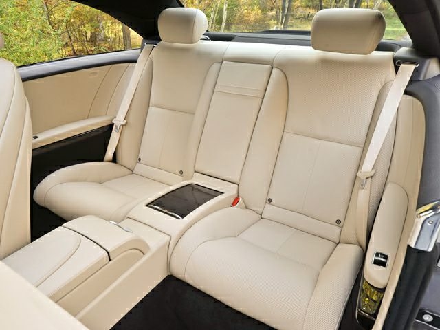 Beige leather rear seats with central armrest and seatbelts