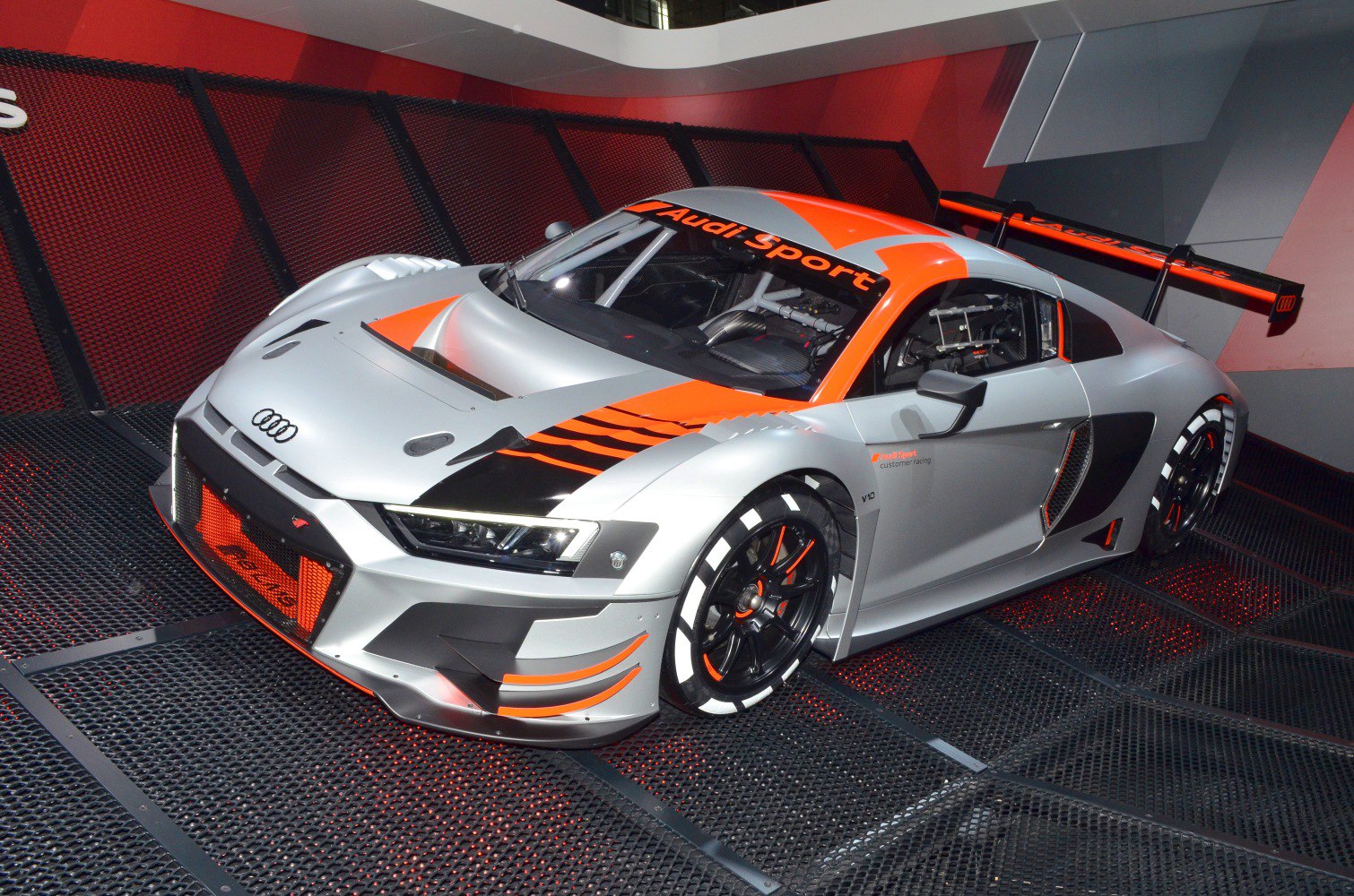 Aerodynamic race car with large rear wing and racing livery
