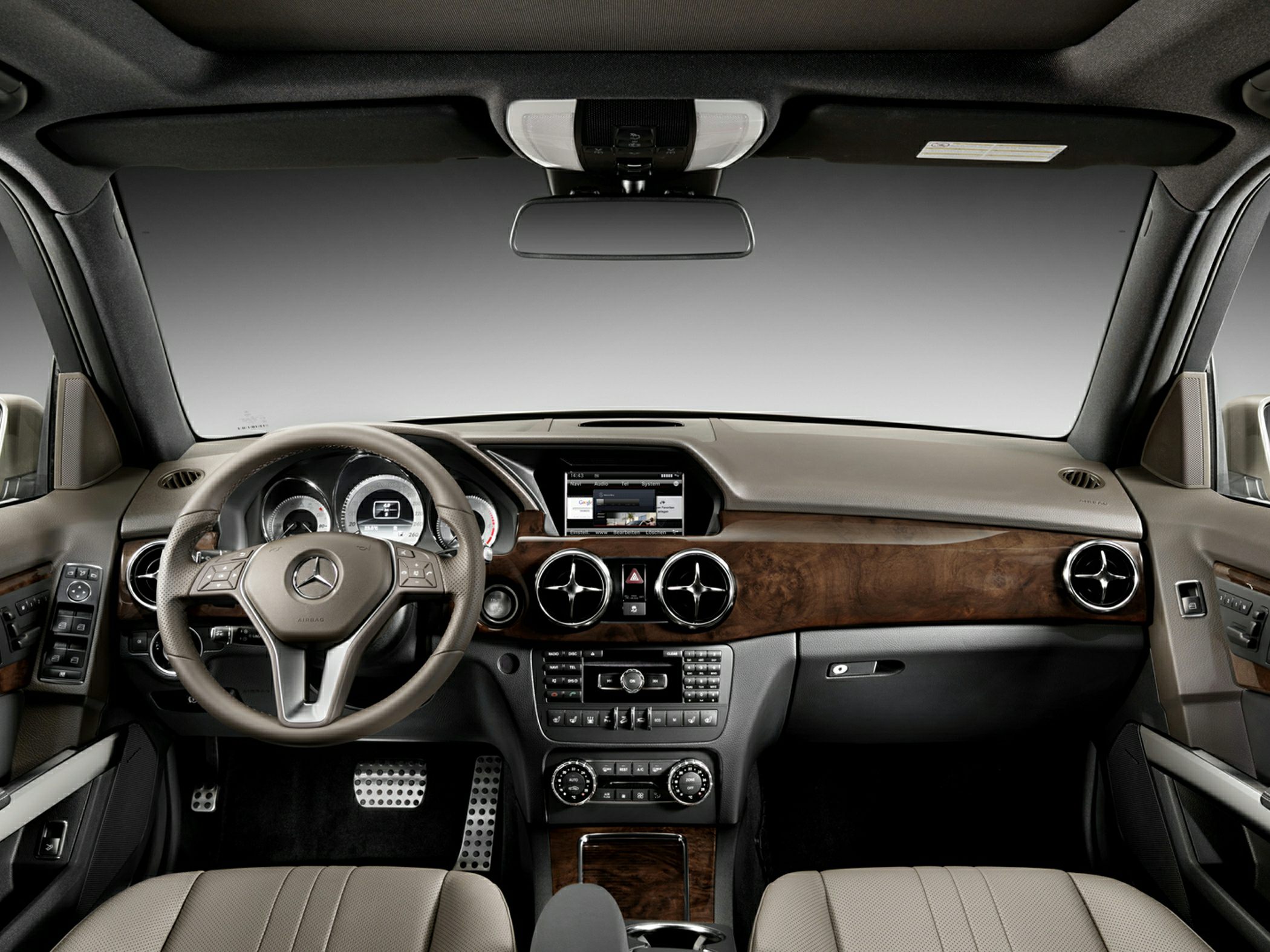 Luxury dashboard and steering wheel with wood trim and embedded infotainment system