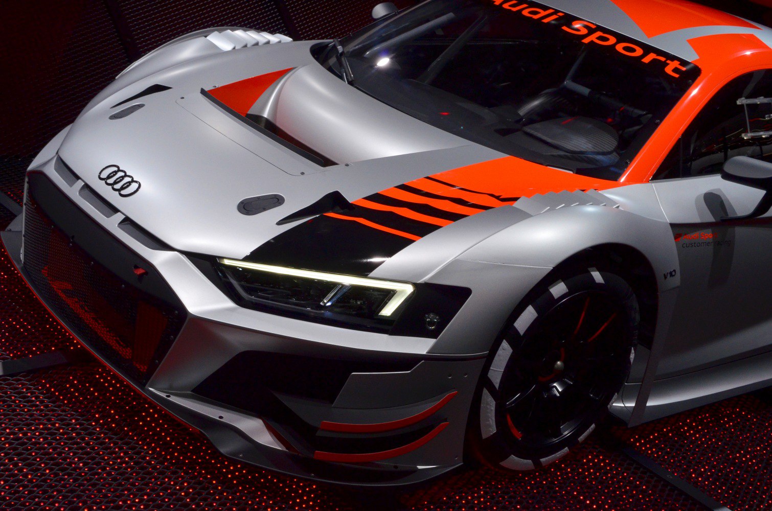 Close-up of aerodynamic front, LED headlight, race decal, and tire.
