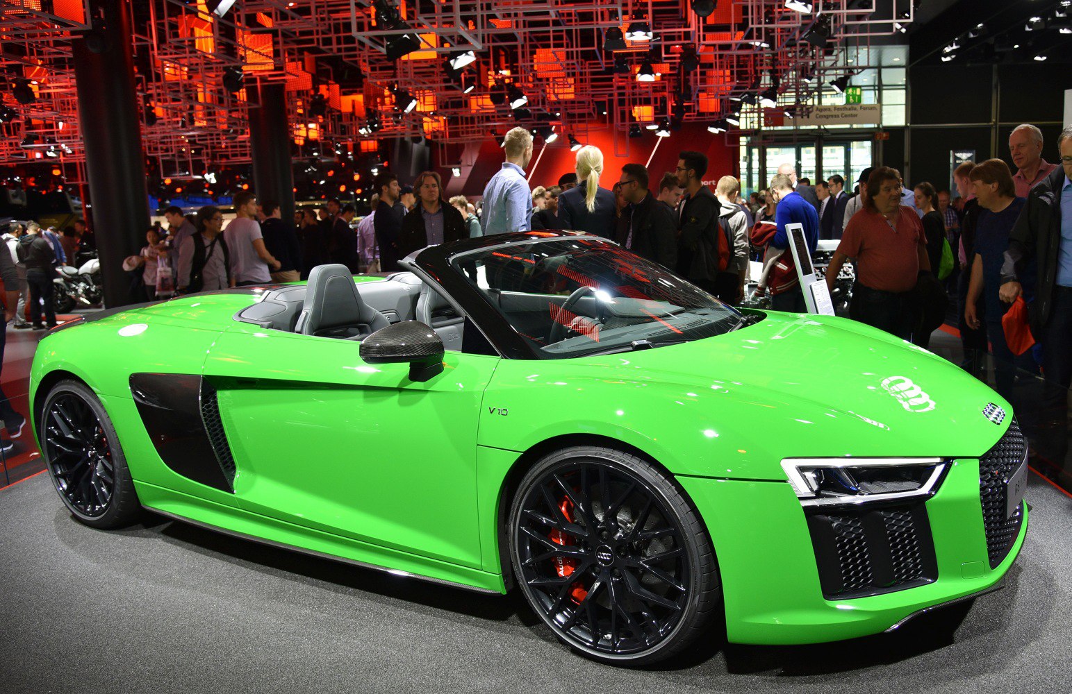 Vibrant green convertible sports car with black rims and aggressive front air intakes