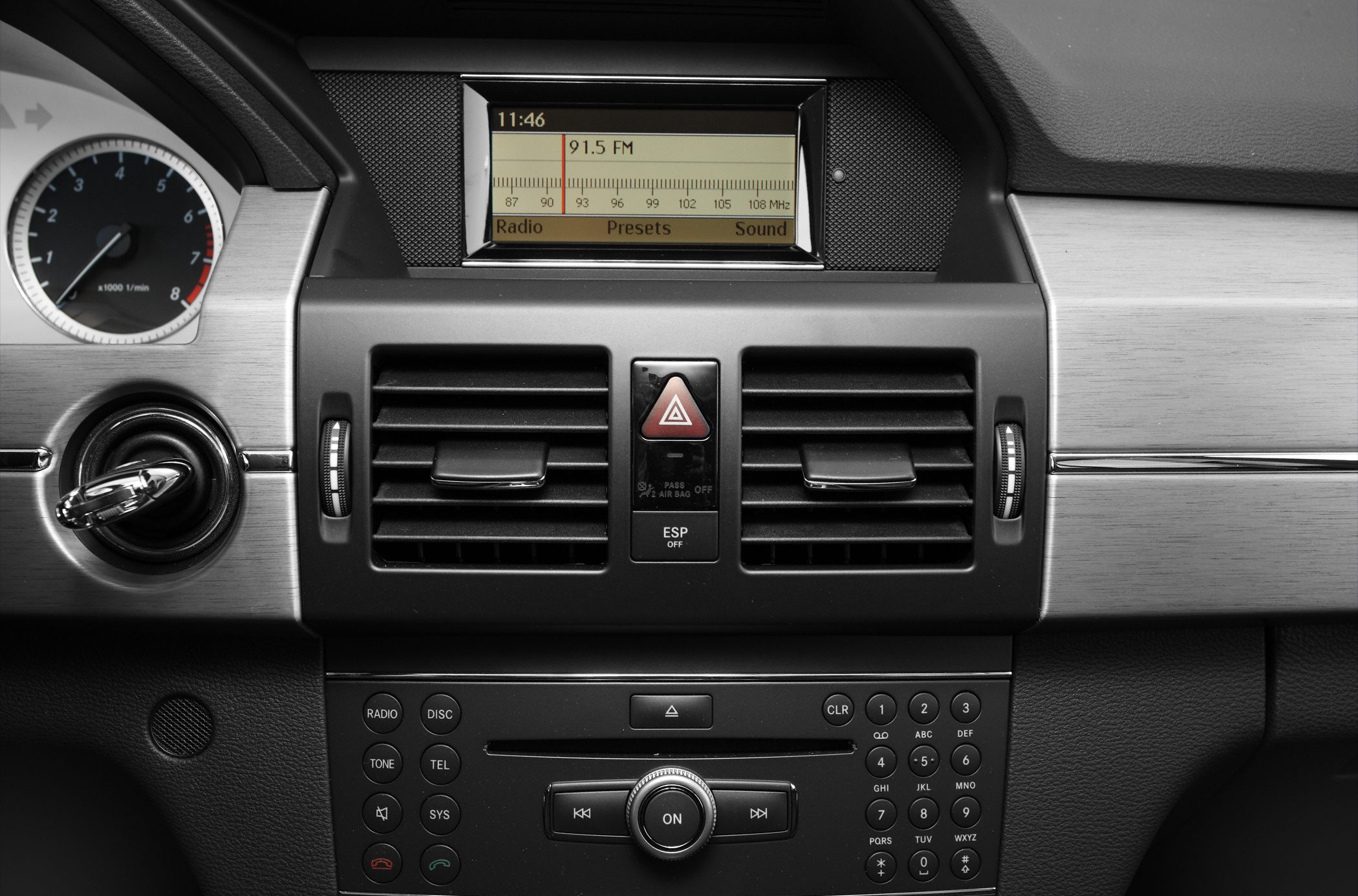 Central air vents, radio display, and control panel in a vehicle dashboard.