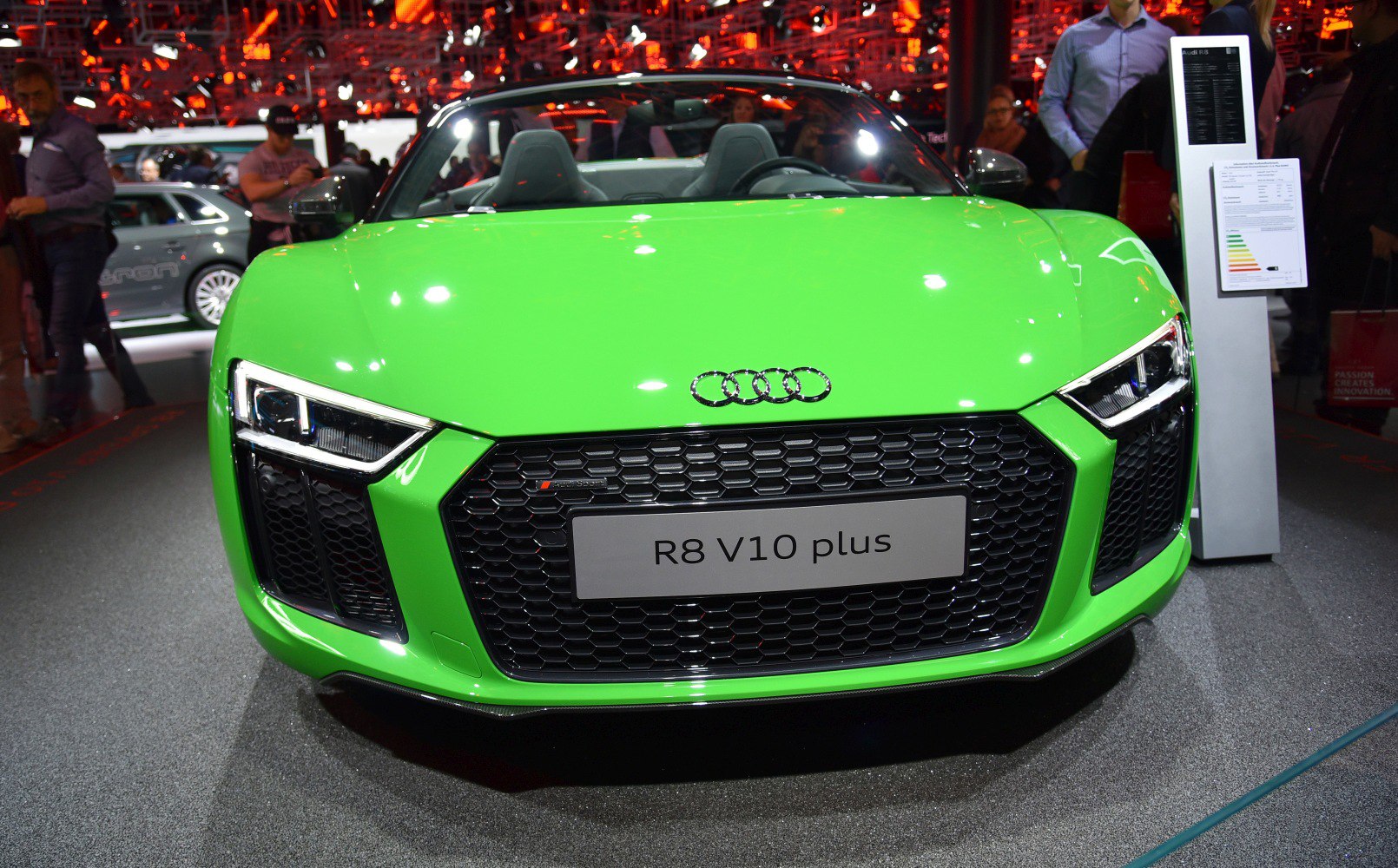 Front grille and sharp headlights of a green convertible sports car