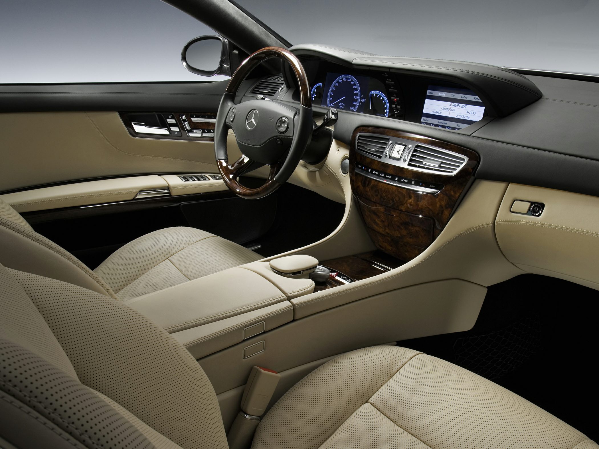 Luxury interior with beige leather seats, wood trim, digital dashboard