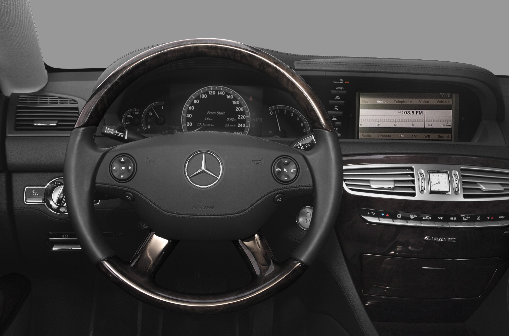 Steering wheel and dashboard with wood trim and infotainment screen