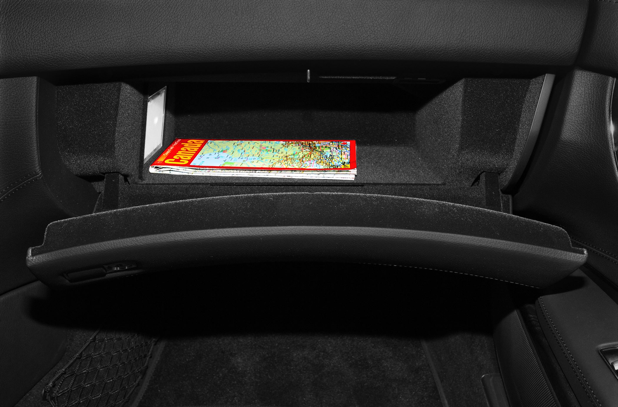 Open glove compartment showing interior storage with map inside