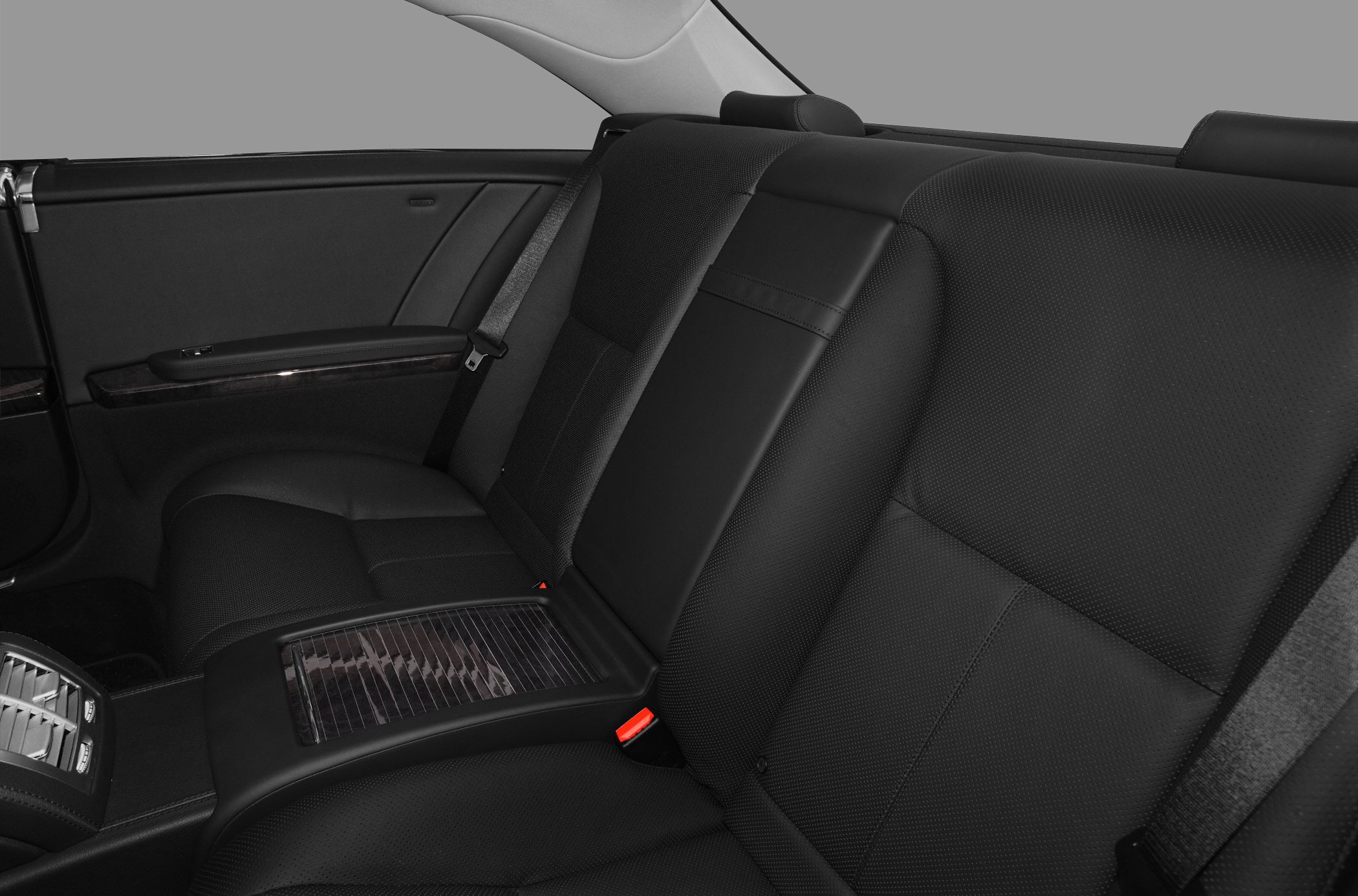 Black leather rear seats with armrest and seatbelt in luxury car interior