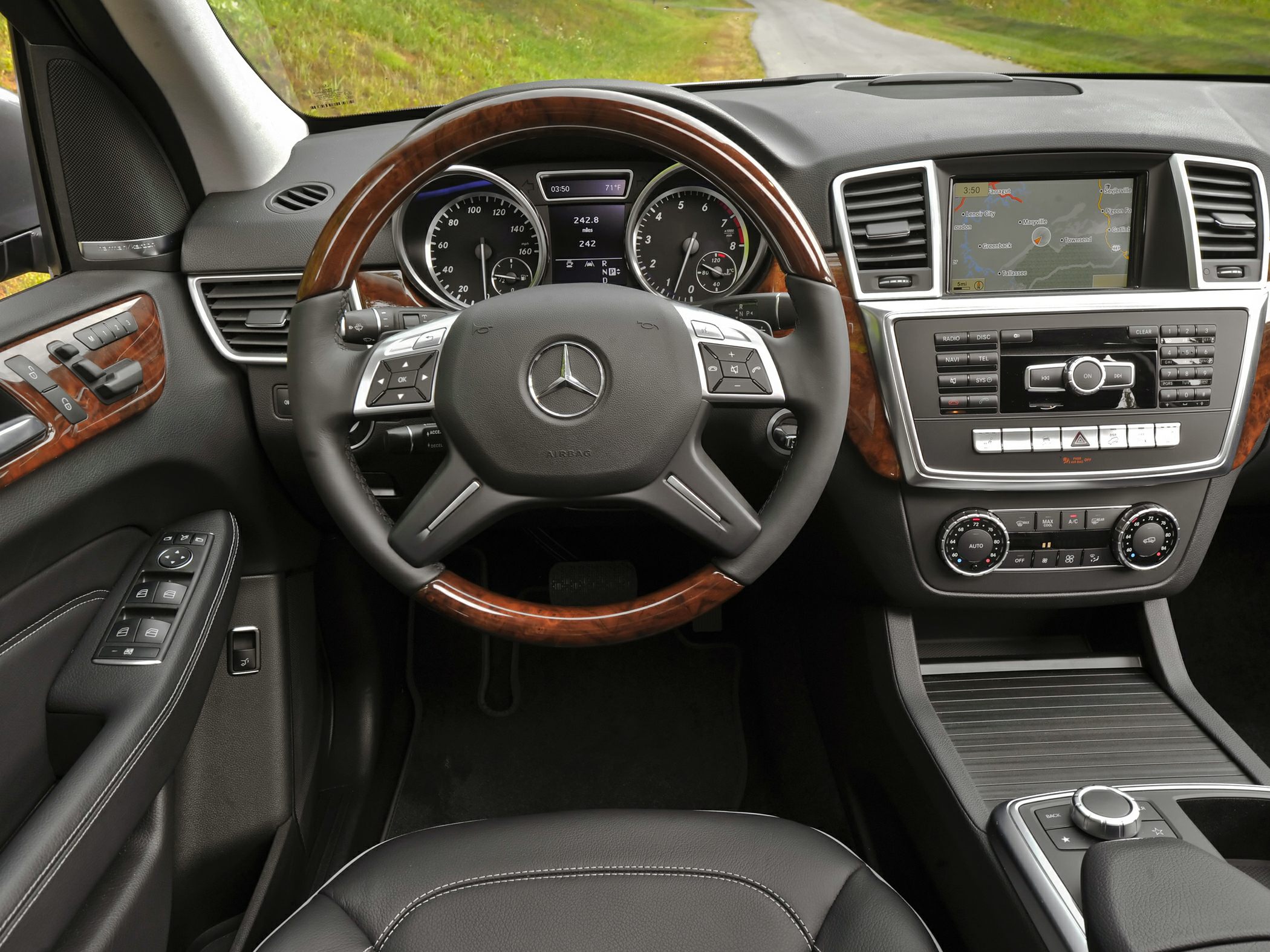 Luxury SUV interior with wood trim steering wheel and digital instrument cluster