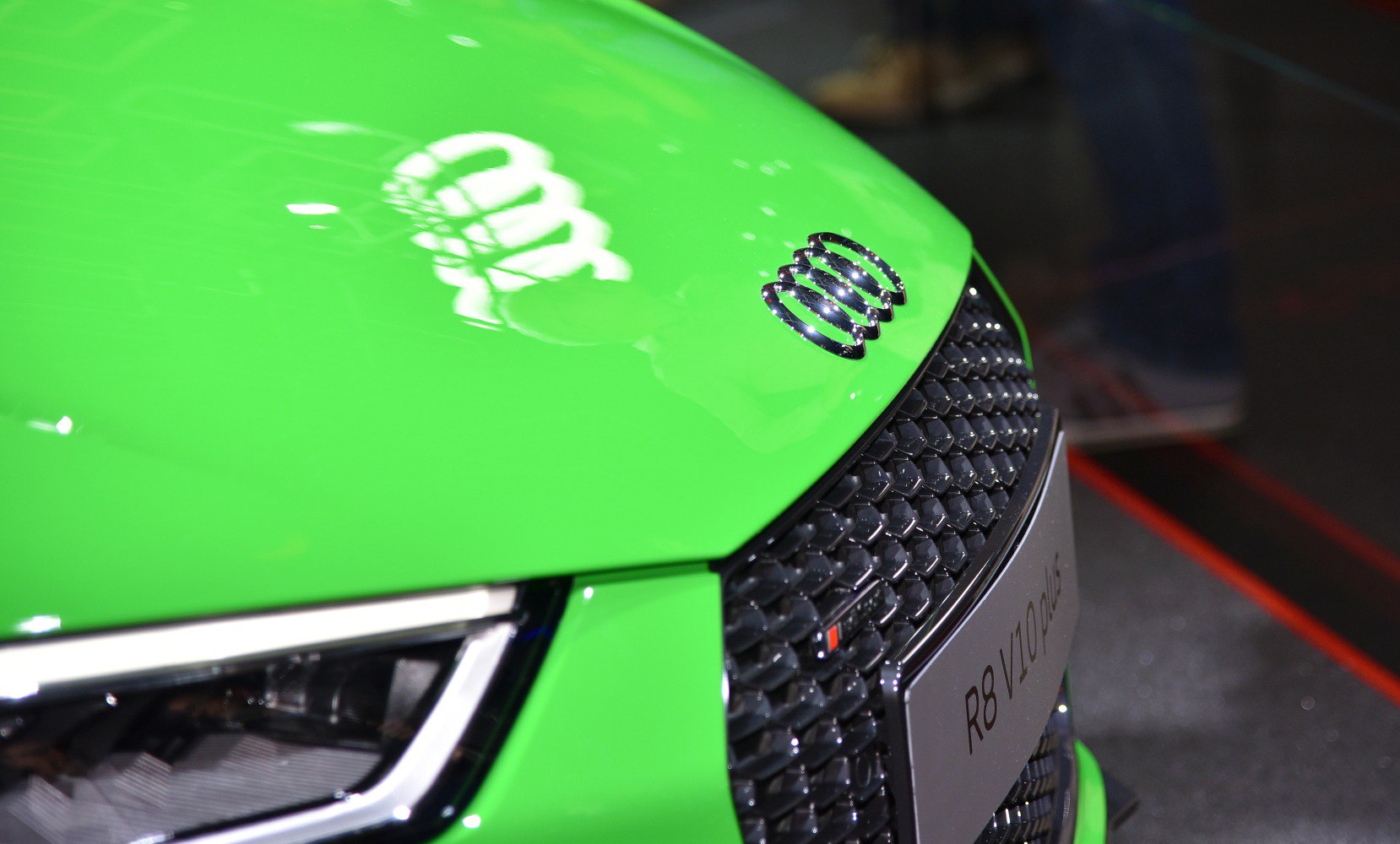 Close-up of front grille and headlight on green sports car