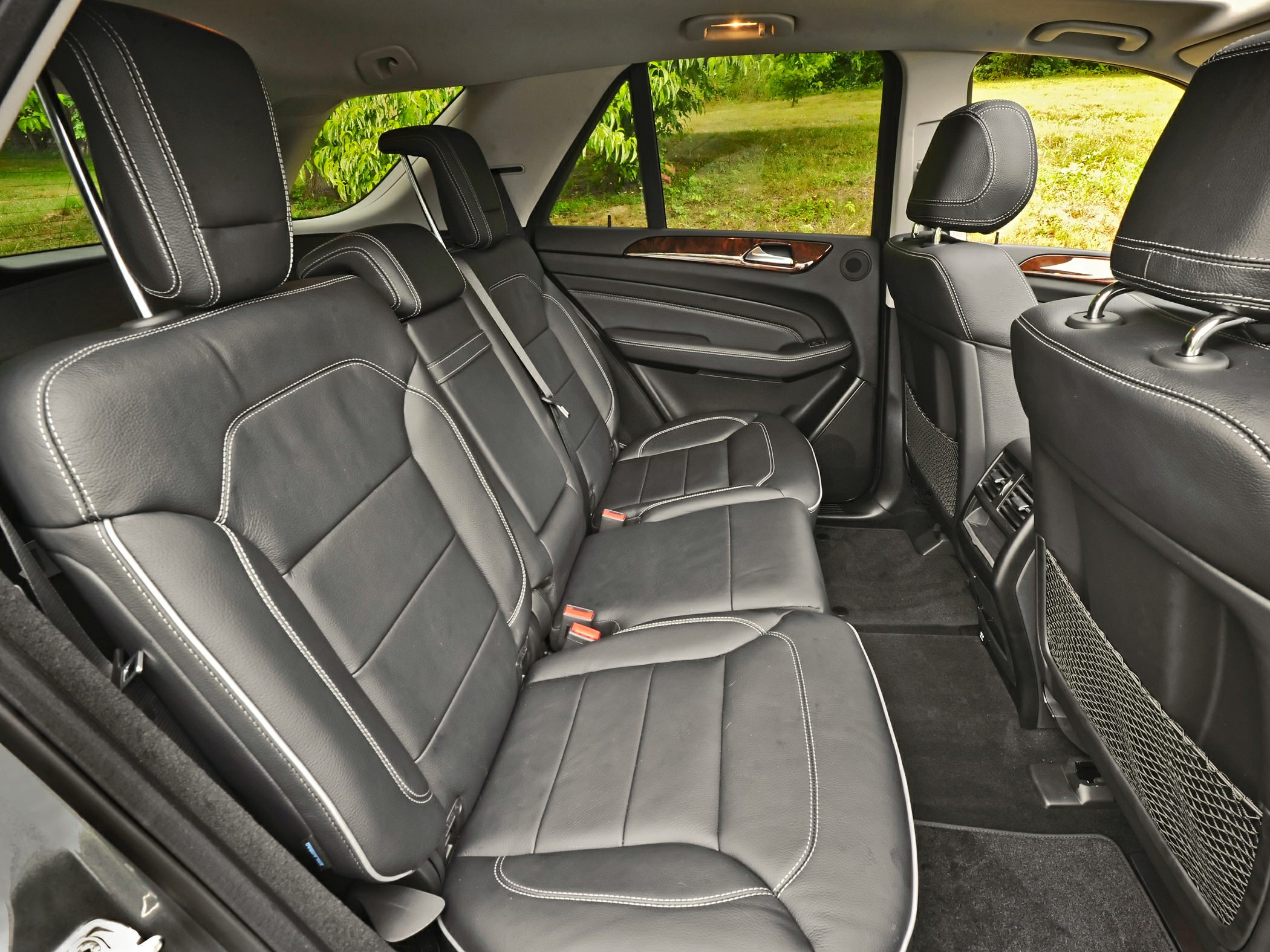 Black leather rear seats with white stitching and spacious legroom.