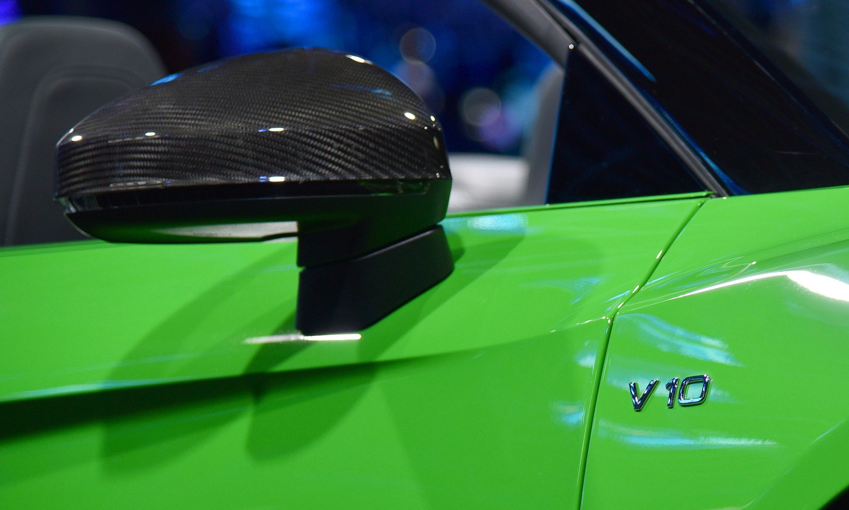 Carbon fiber side mirror and V10 engine badge on green sports car
