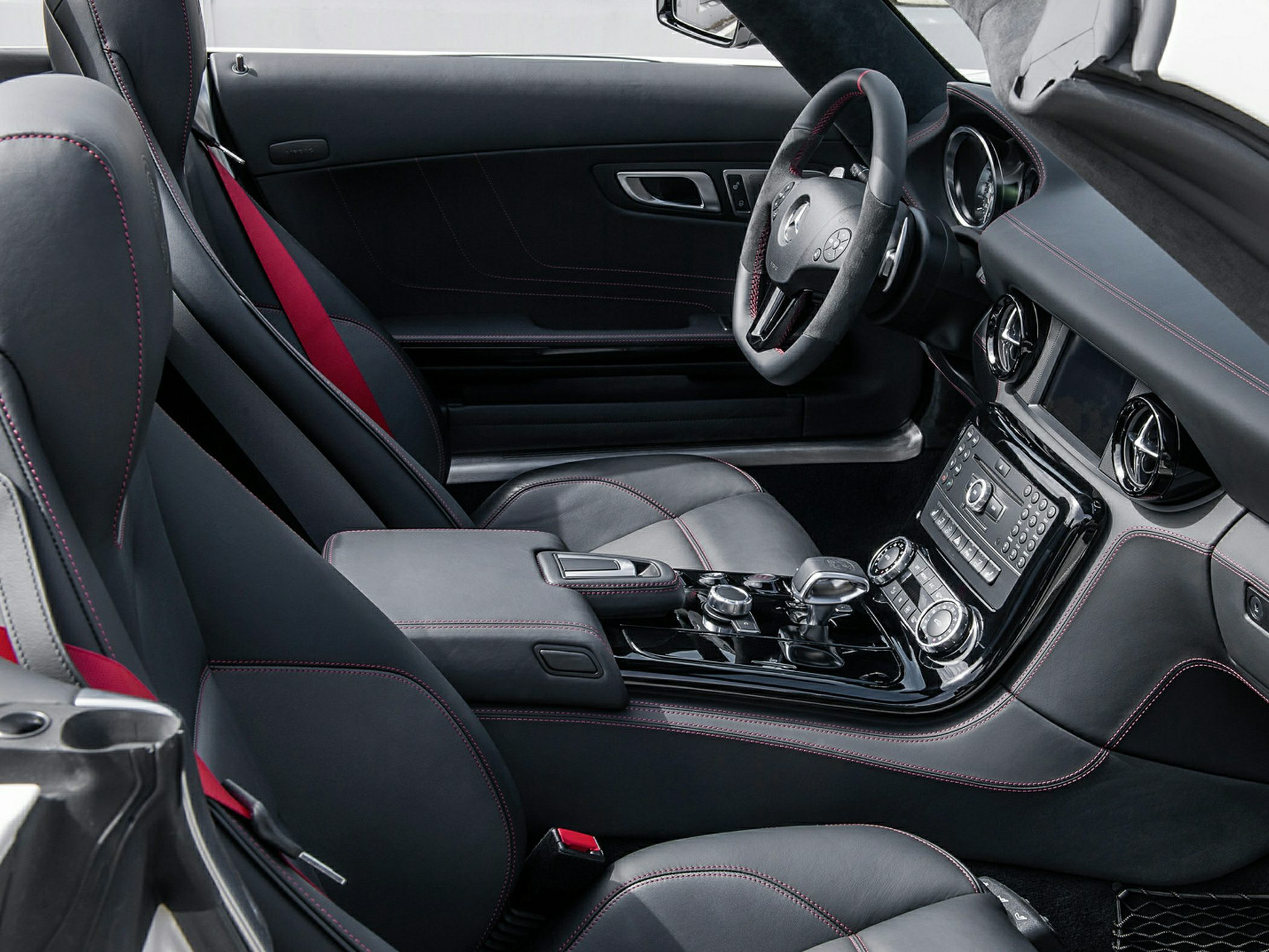 Luxurious sports car leather interior with red seat belts and stitching