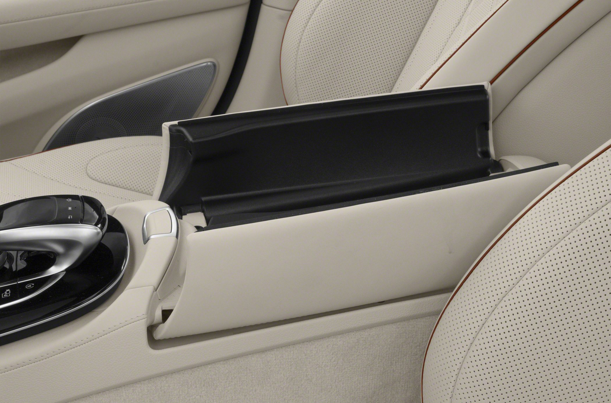 Open center console storage compartment and beige leather seats
