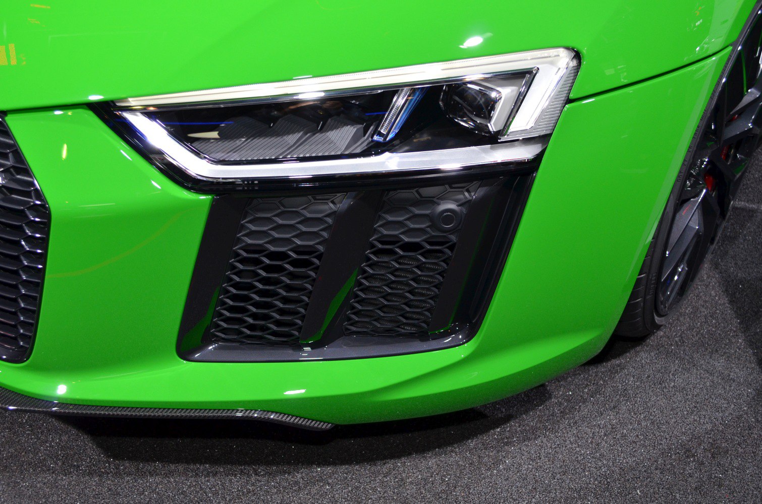 Close-up of sporty front LED headlight and honeycomb grille