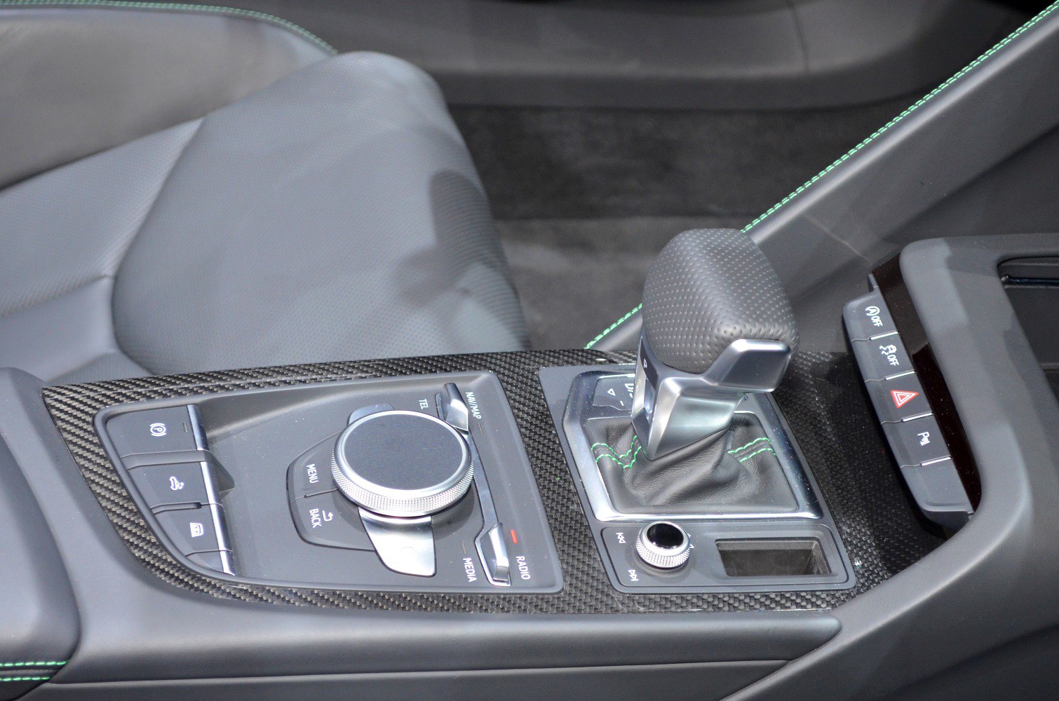 Interior center console with gear shifter and multimedia control knob on carbon fiber trim