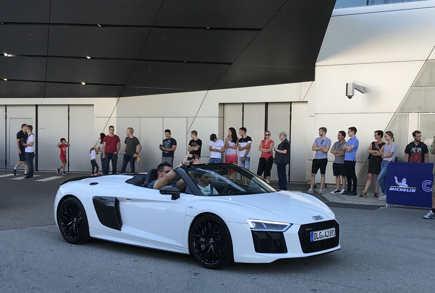 White convertible sports car with black wheels and aerodynamic side air intakes