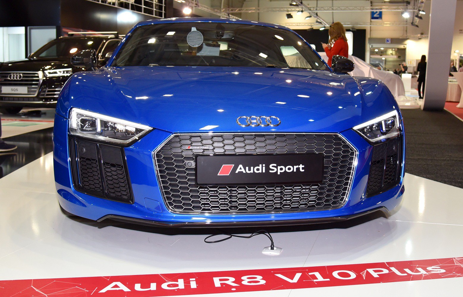 Front view of blue sports coupe with LED headlights and honeycomb grille
