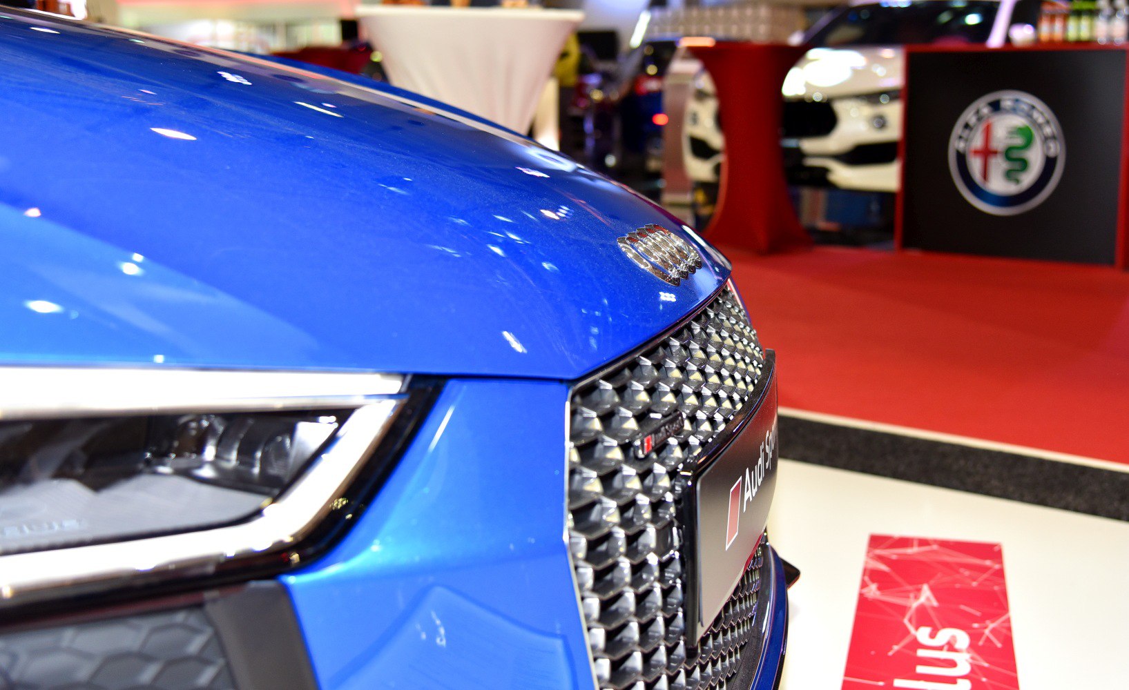 Close-up of front grille and headlight of blue luxury sports car