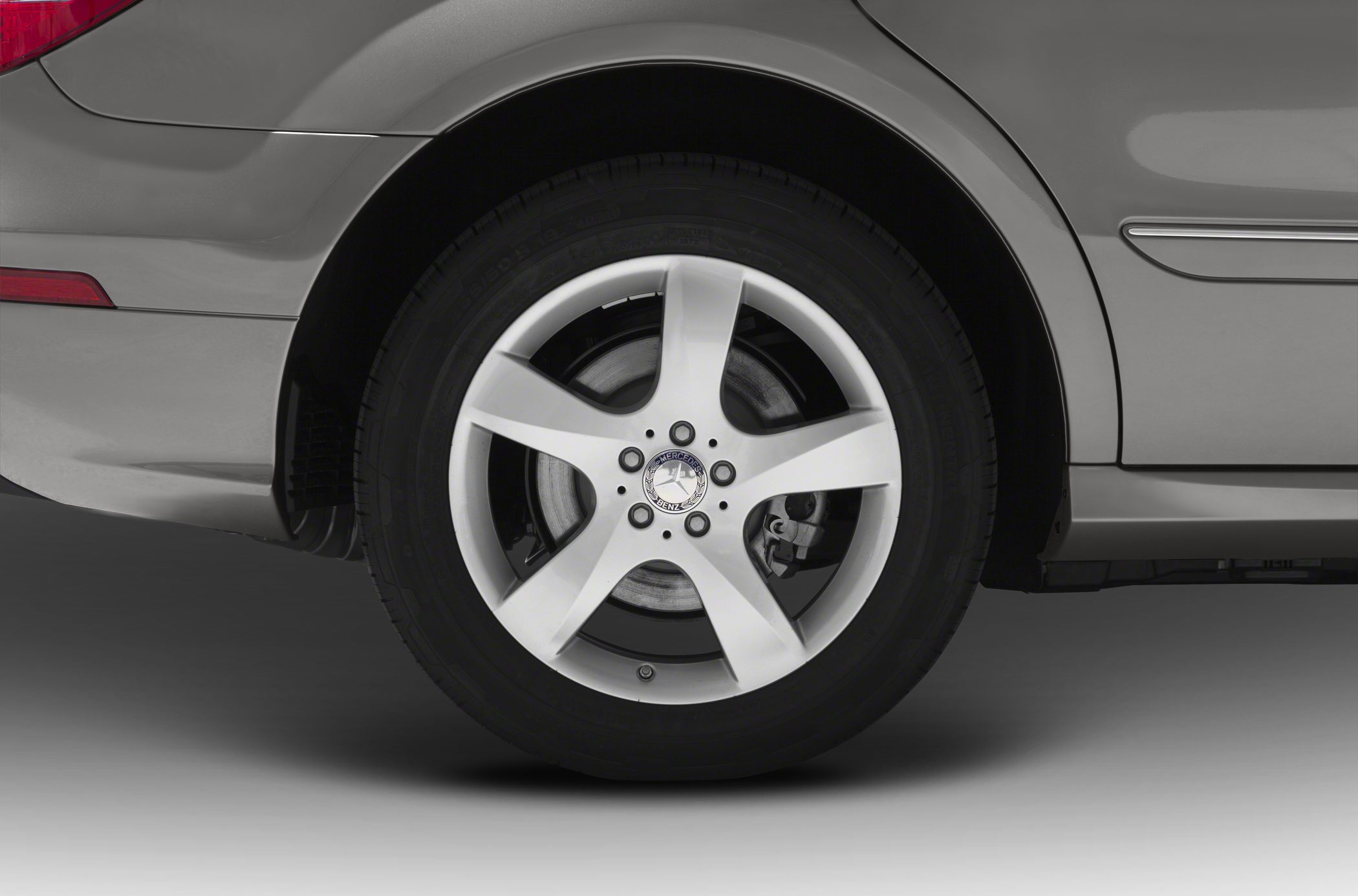 Close-up of a 5-spoke alloy wheel with rear fender and brake caliper detail
