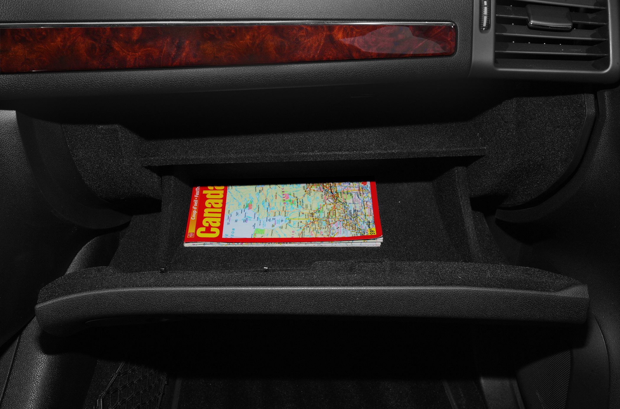 Open glove box with a map inside in car interior