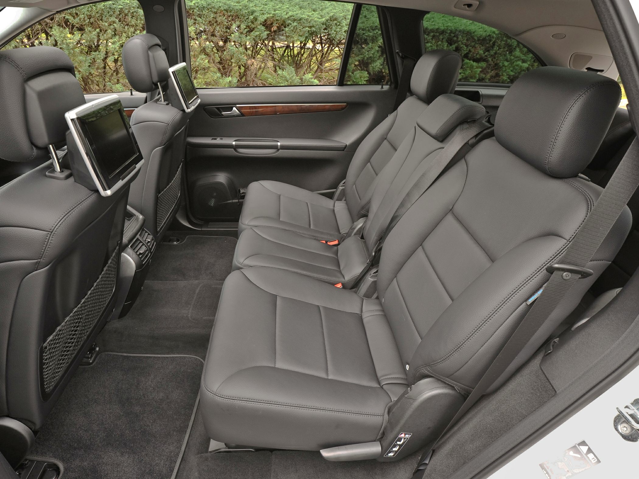 Black leather rear seats with integrated headrest monitors and wood trim