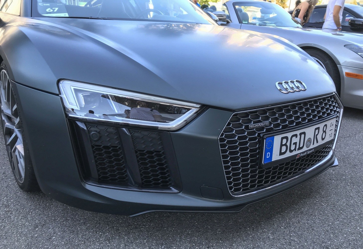 Close-up of front grille, headlight, and front bumper of a sports coupe