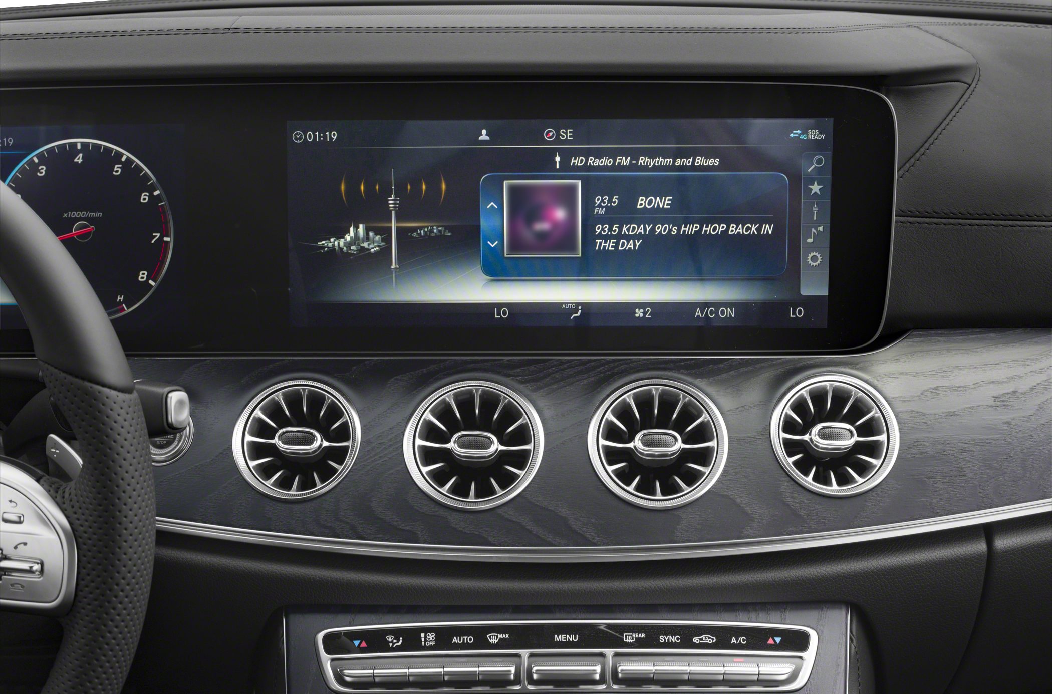 Digital instrument cluster and four circular air vents on a luxury car dashboard