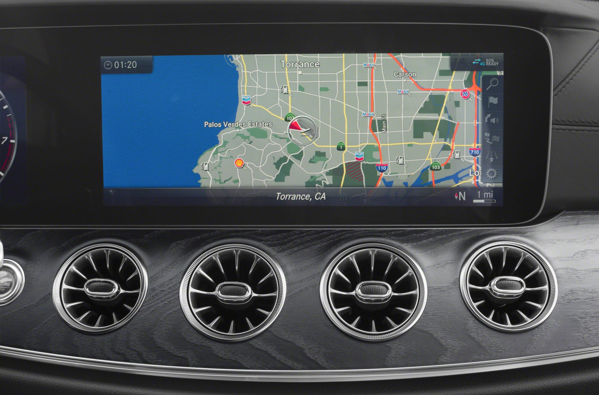 Car dashboard with navigation screen and four circular air vents
