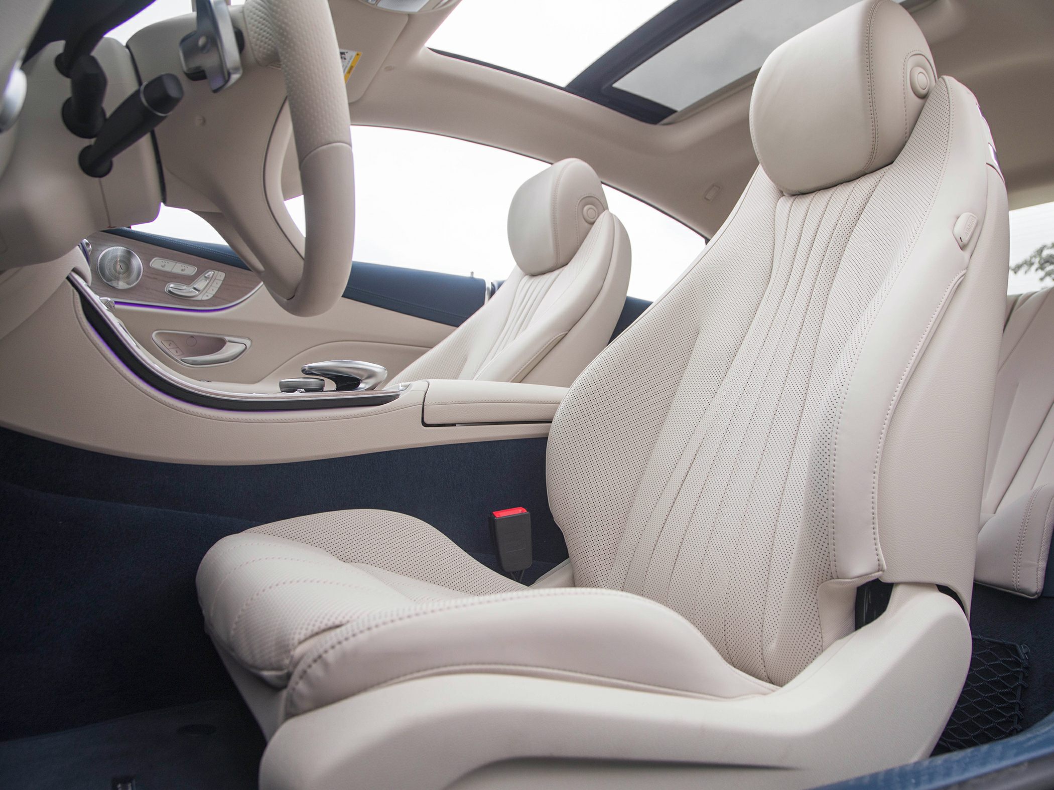 Beige perforated leather seats with adjustment controls and panoramic sunroof