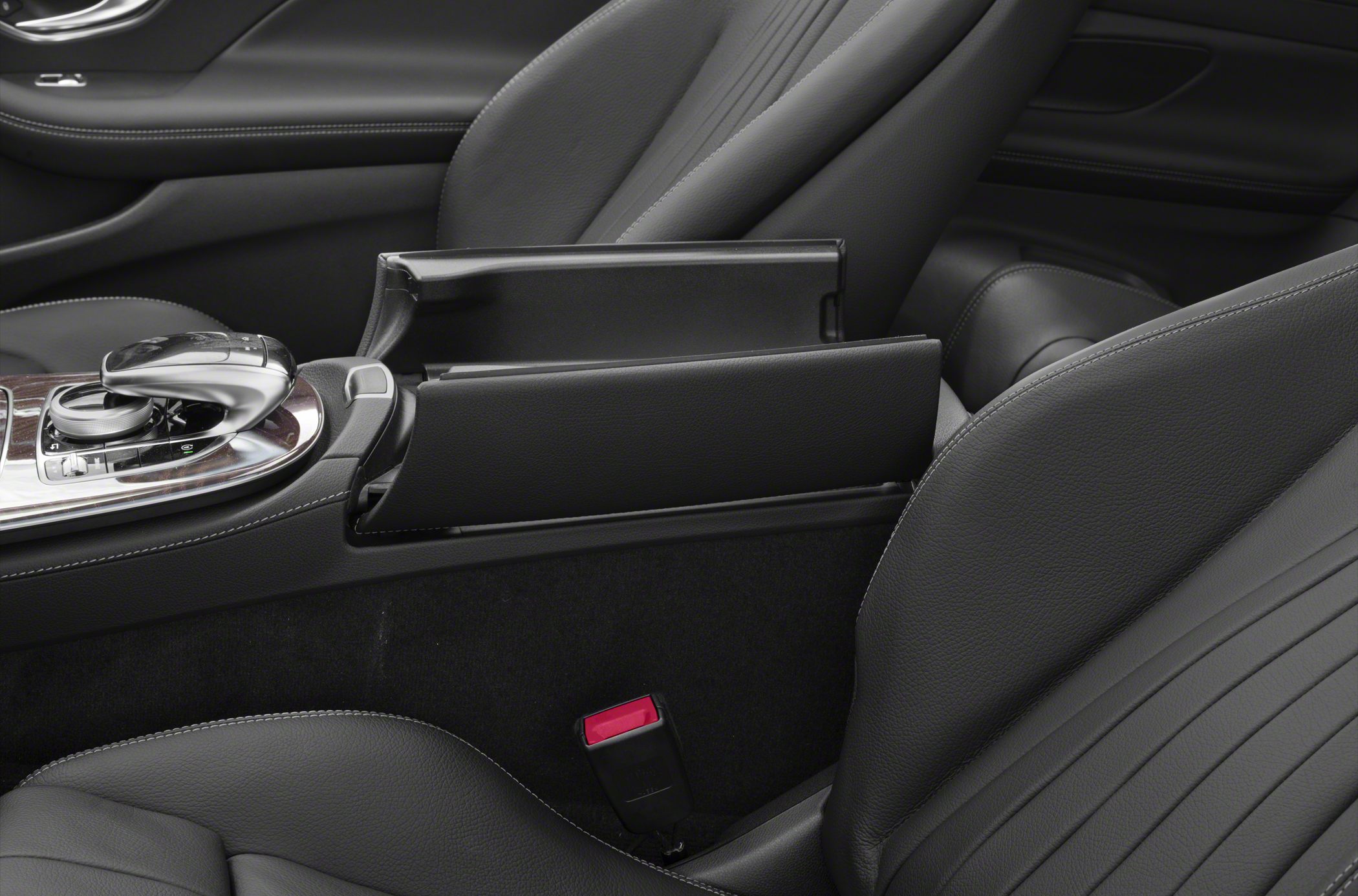 Center console controls and open armrest storage compartment in luxury car interior