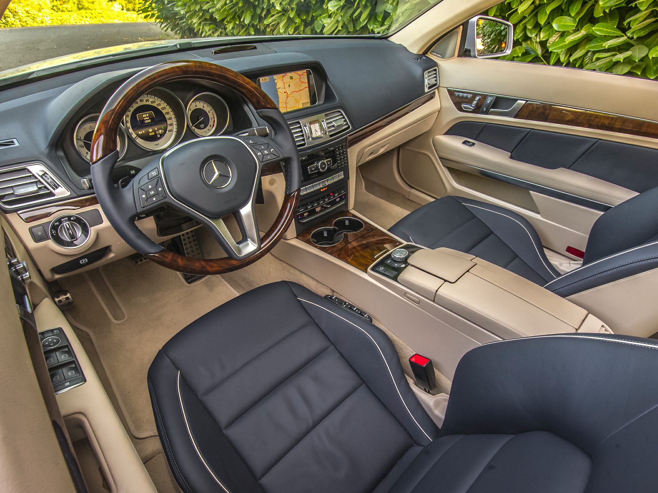 Luxury car interior with wood trim, leather seats, and navigation screen