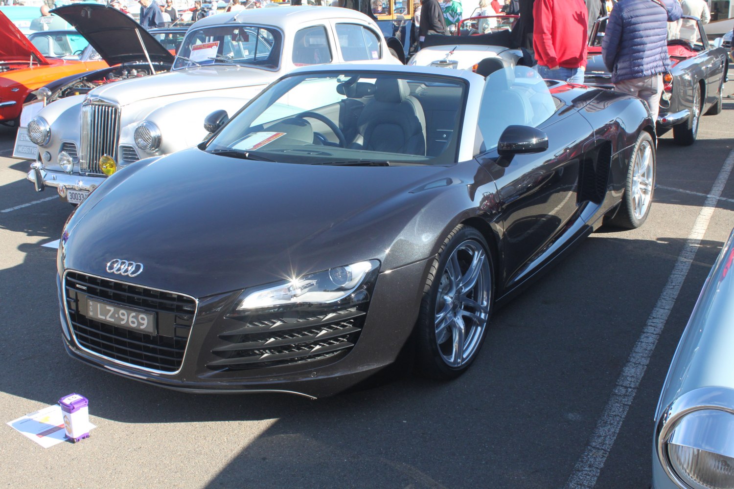 Front view of a sleek black convertible sports car with distinctive grille and alloy wheels