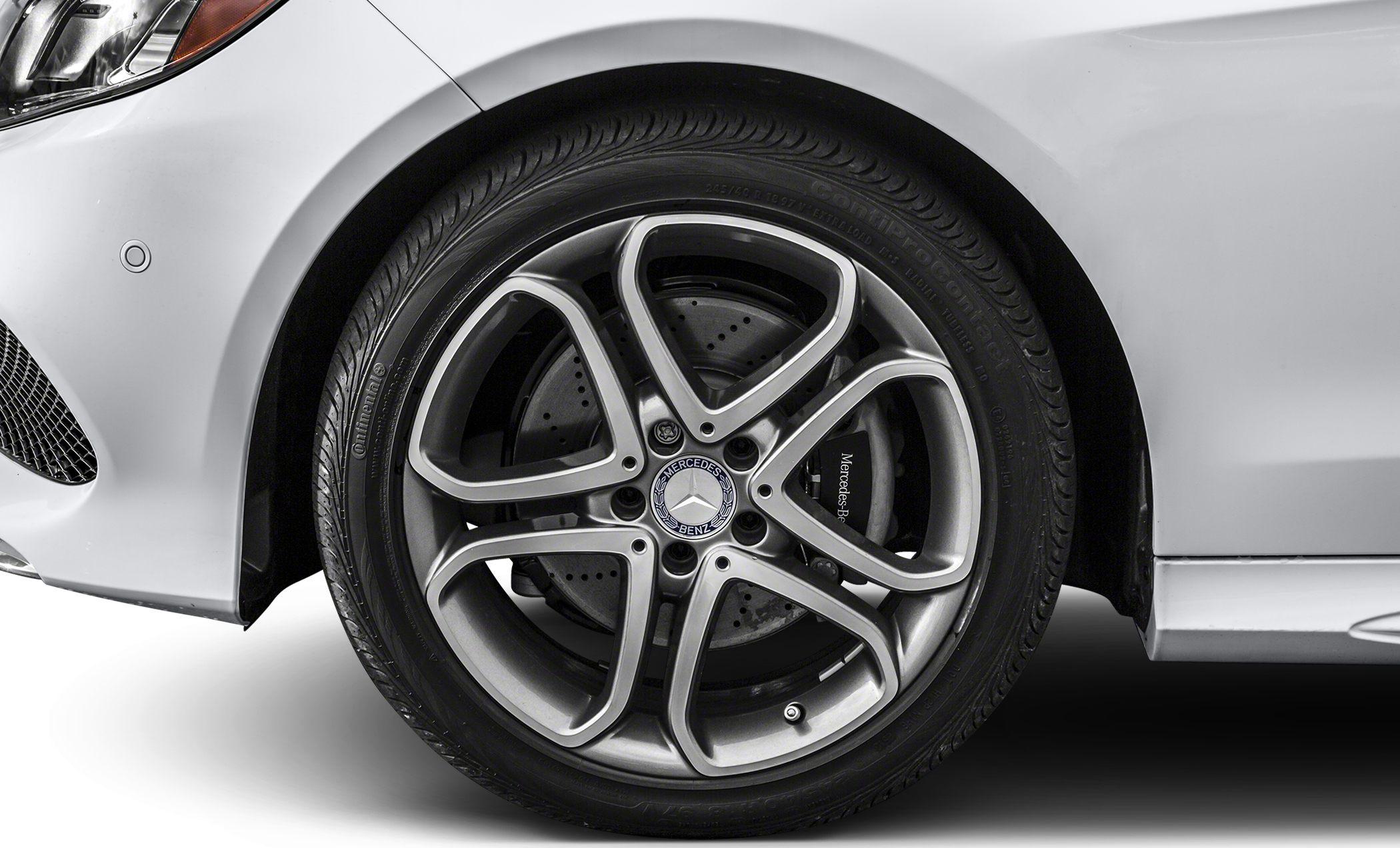 Alloy wheel with perforated brake disc and tire on a silver vehicle