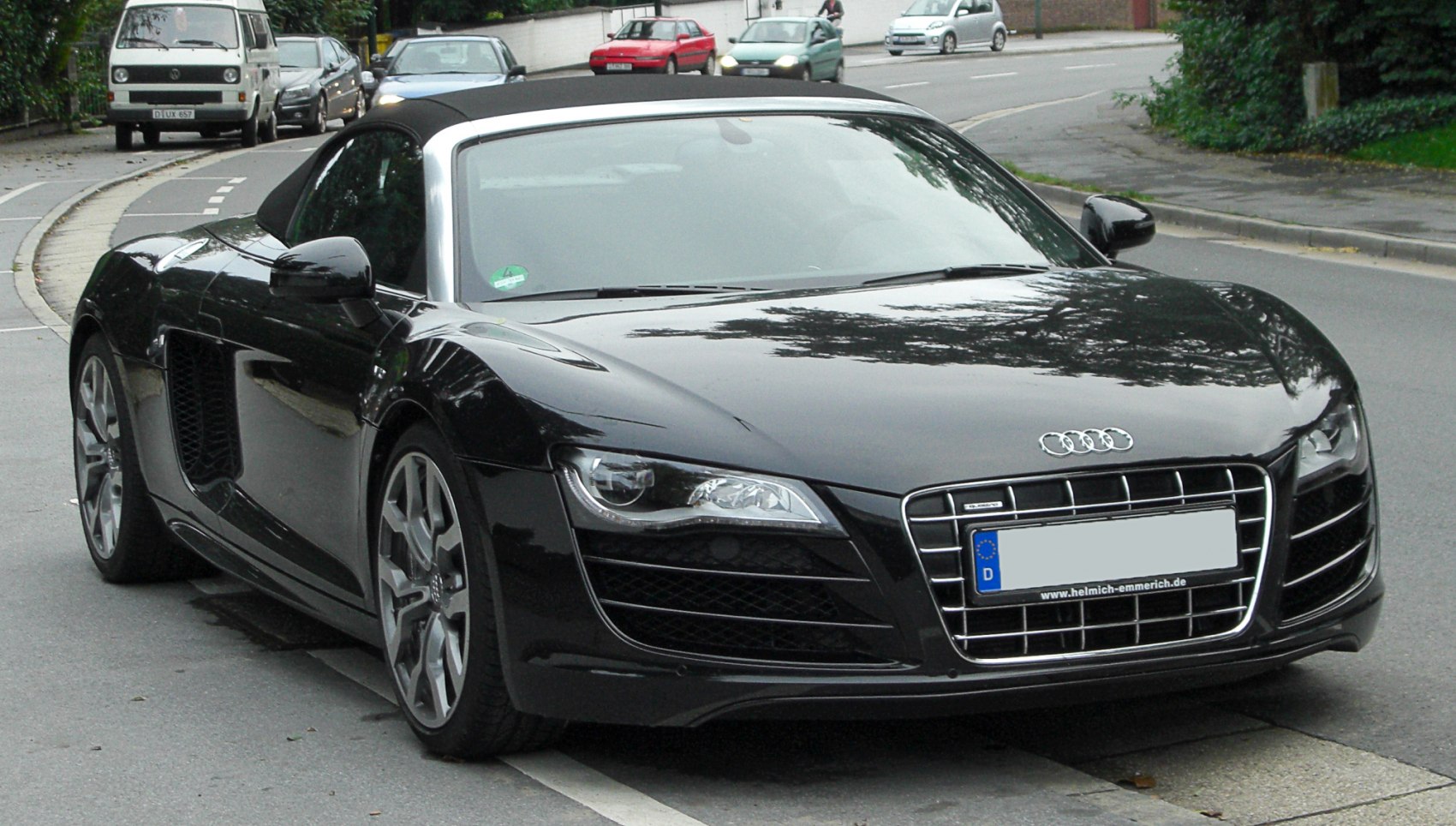 Black convertible sports car with sleek headlights and distinctive grille