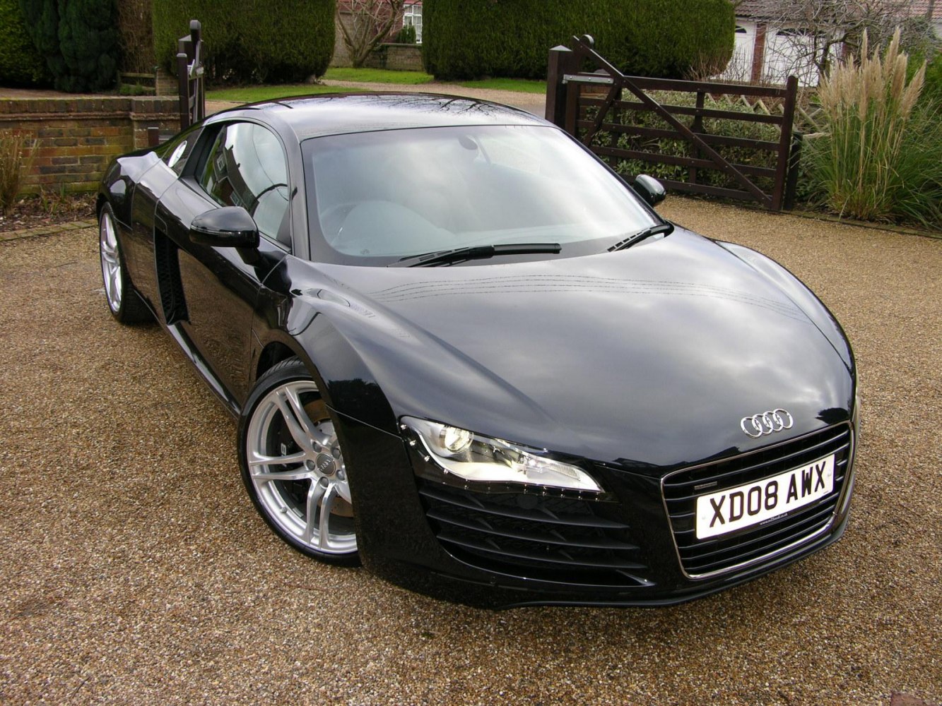 Front and side view of sleek sports car with distinct headlights and aerodynamic design