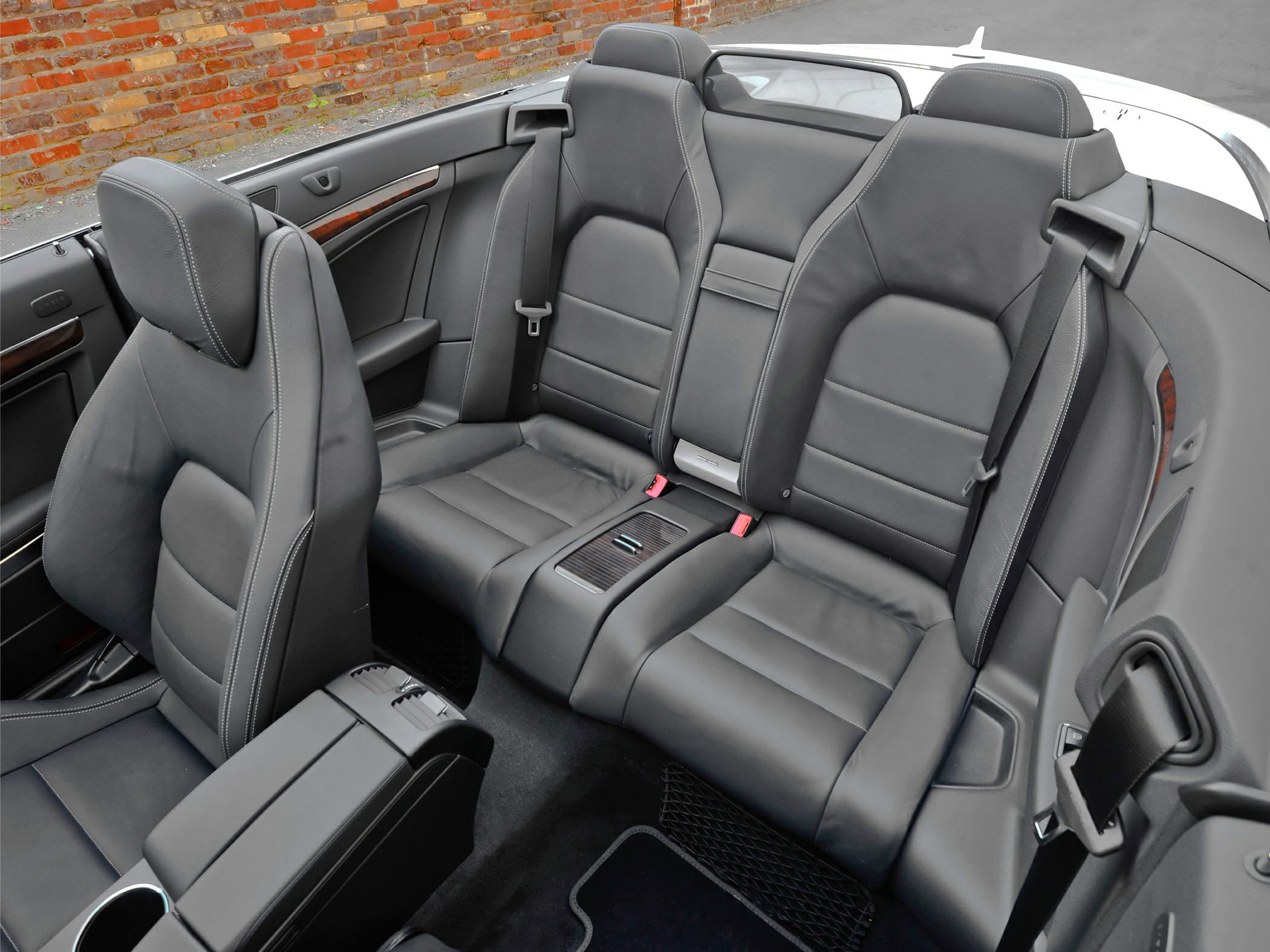 Black leather rear seats with detailed stitching and center armrest.