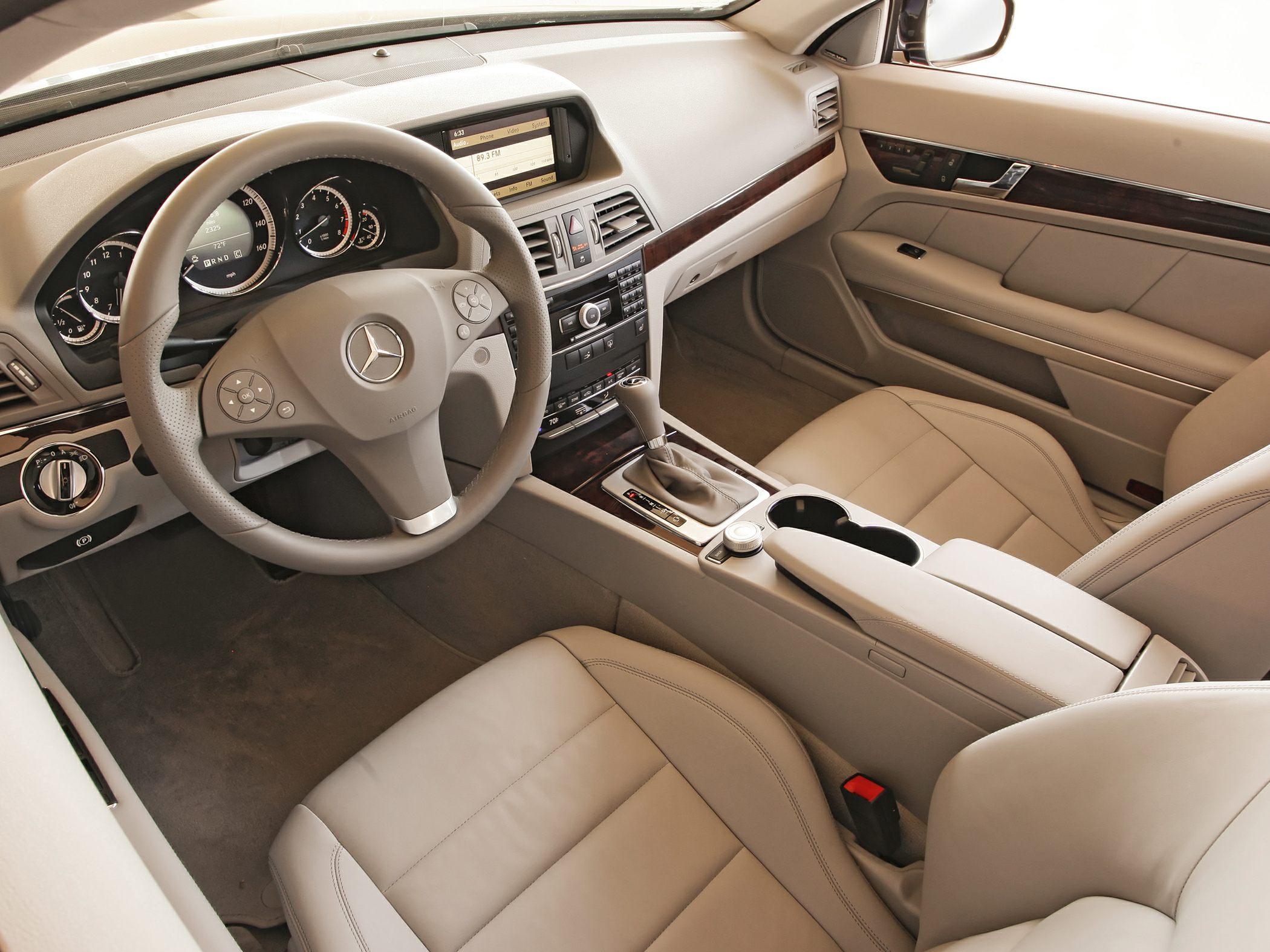 Luxury car interior with steering wheel, dashboard, and center console.