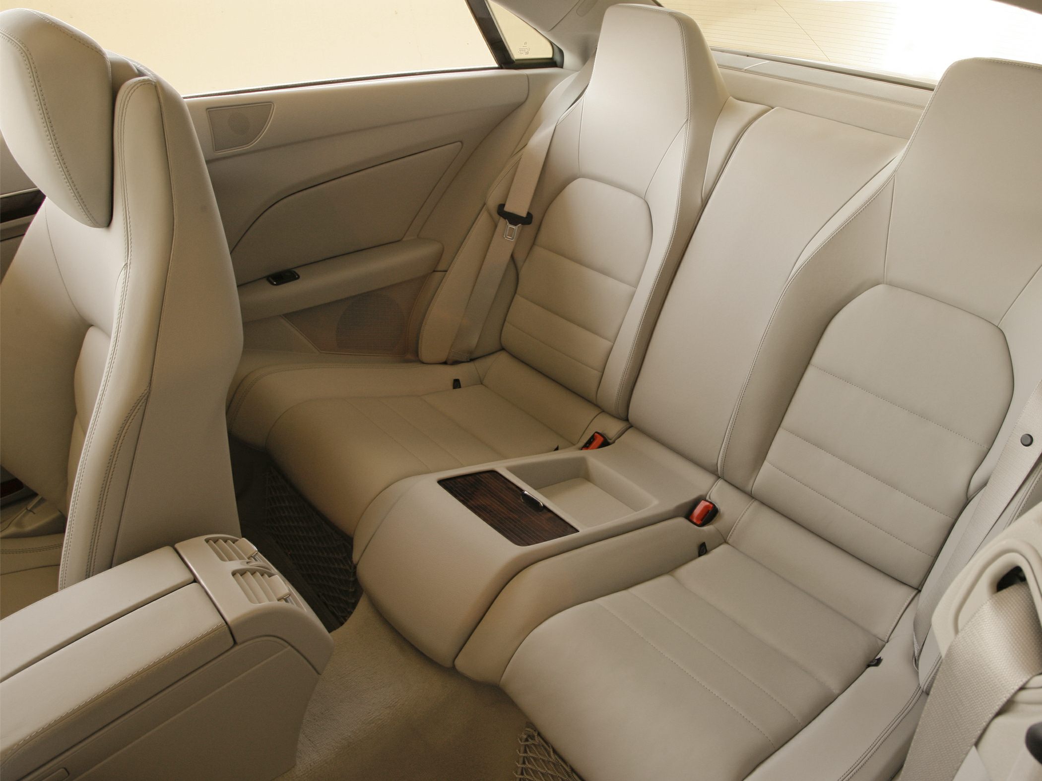 Beige leather rear seats with center armrest and modern design