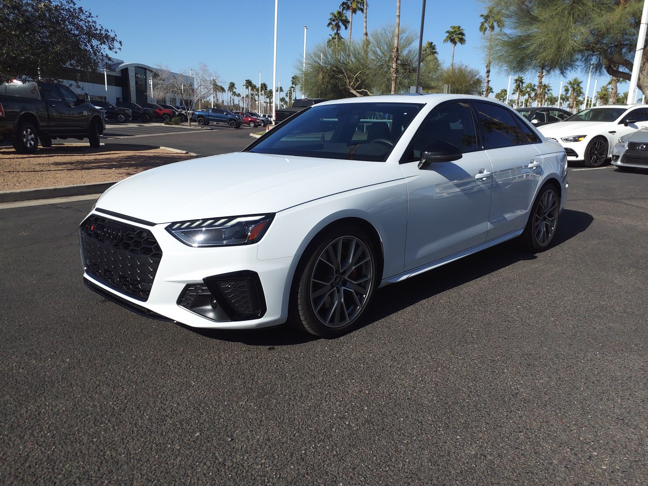 Front three-quarter view of a white sporty sedan with aggressive grille and alloy wheels