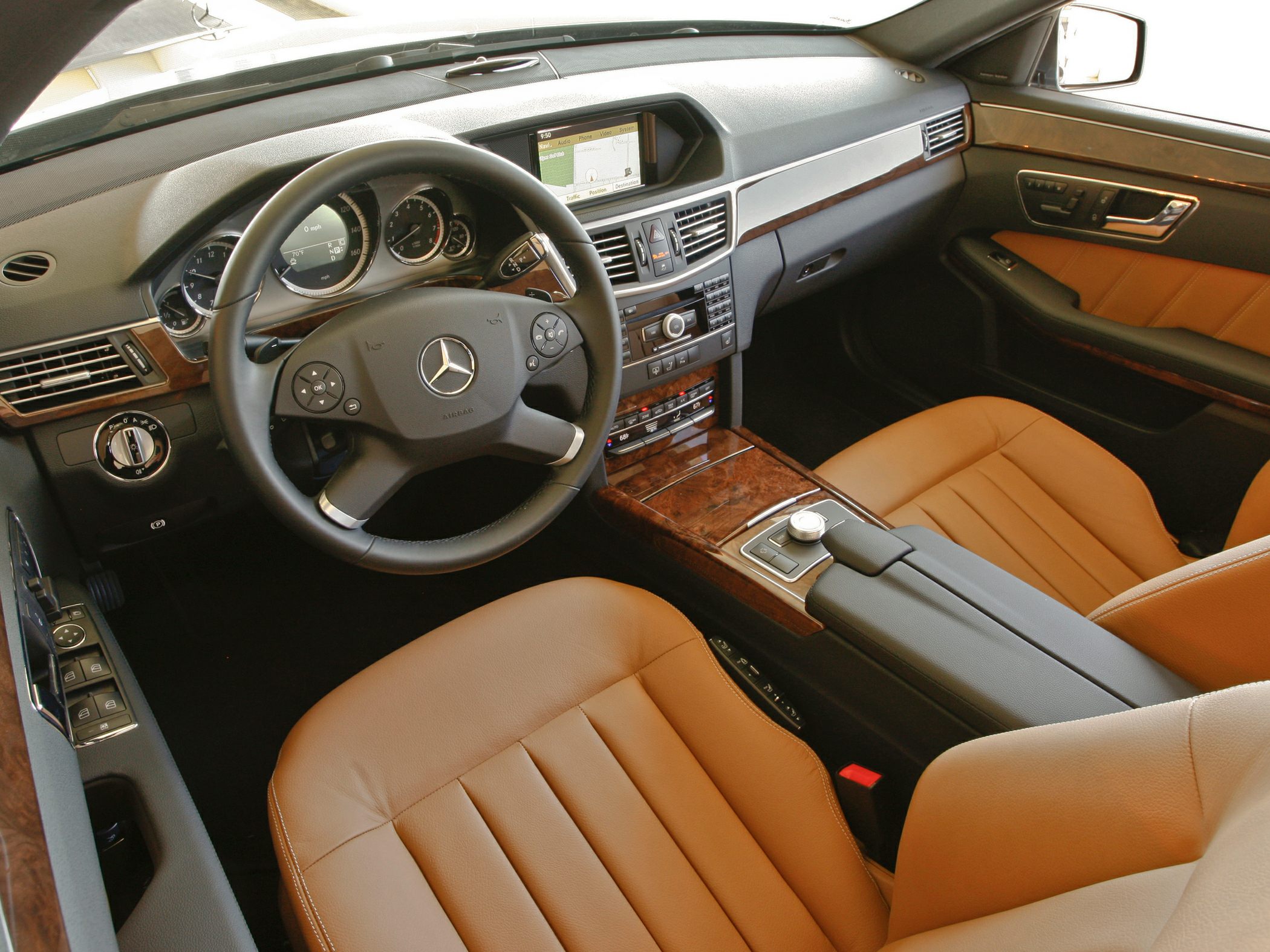 Brown leather seats with wood trim and advanced dashboard controls