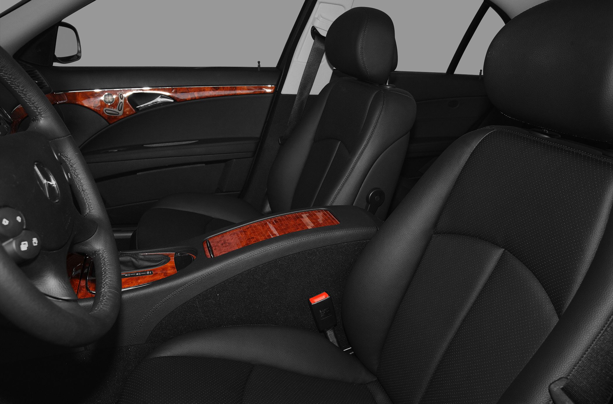 Black leather seats and wood trim interior with steering wheel