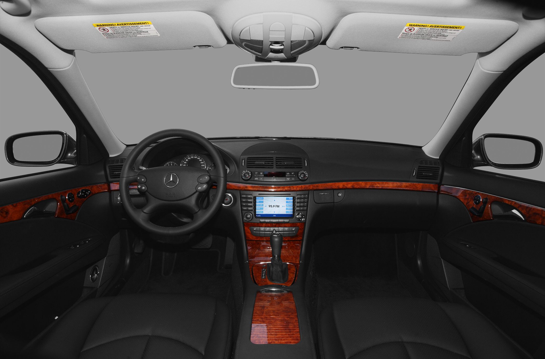 Luxury car interior with dashboard, steering wheel, and wood trim
