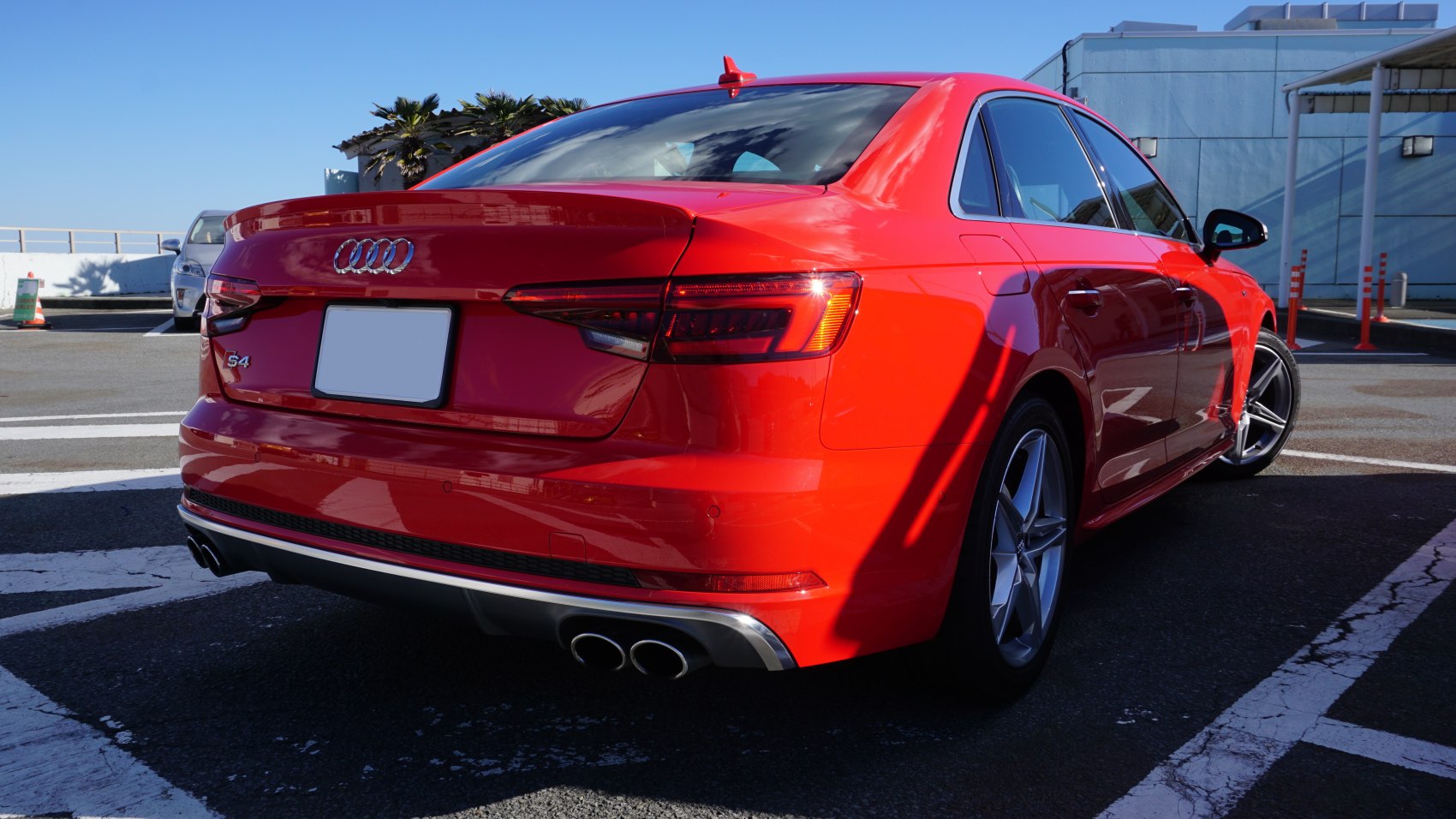 Rear view of red sedan with quad exhaust and LED taillights