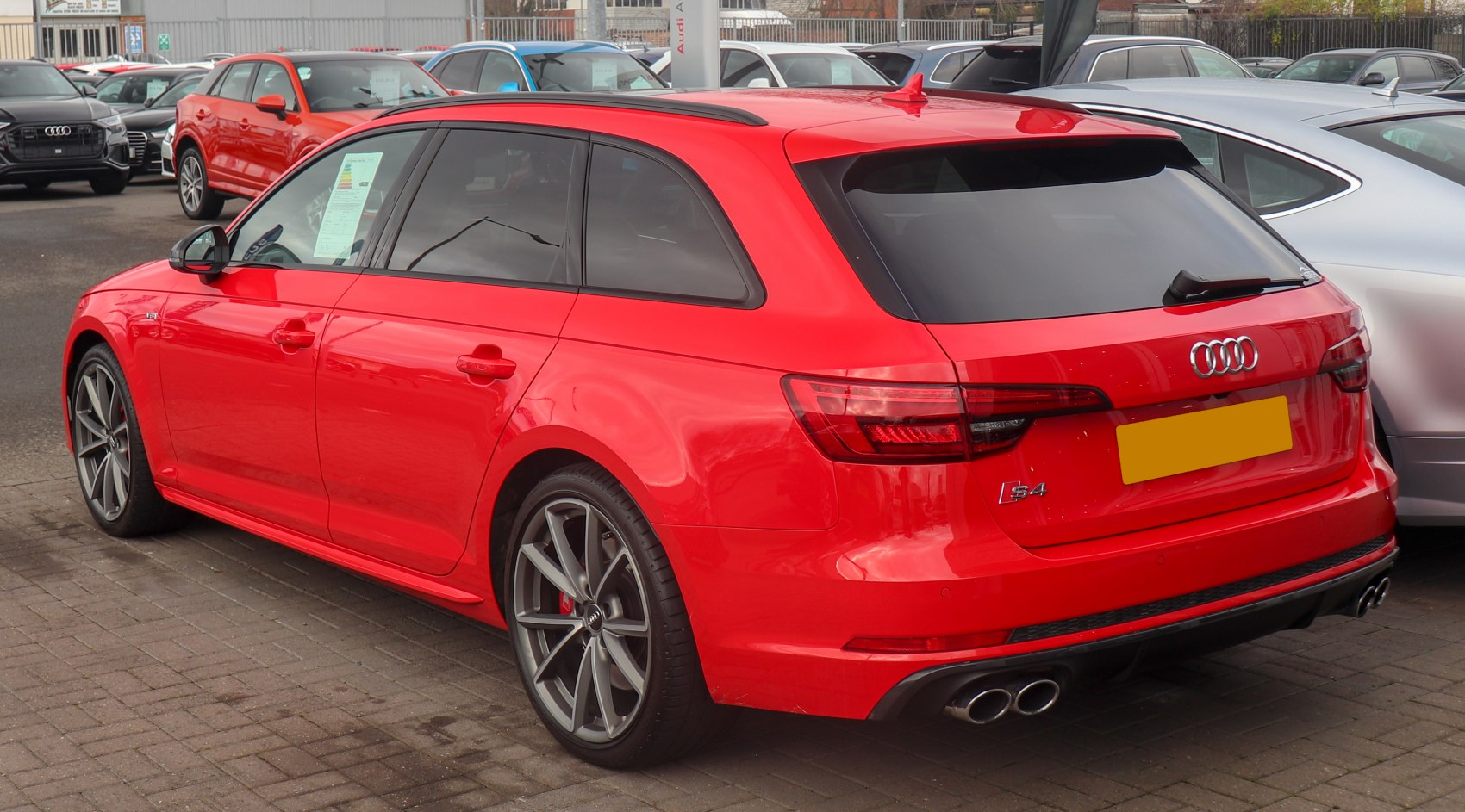 Red station wagon rear-side with quad exhaust and sporty wheels