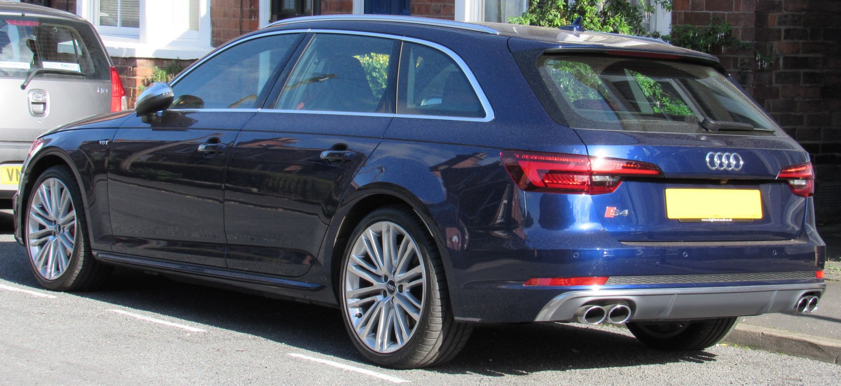 Rear-side view of sporty station wagon with quad exhaust tips and alloy wheels