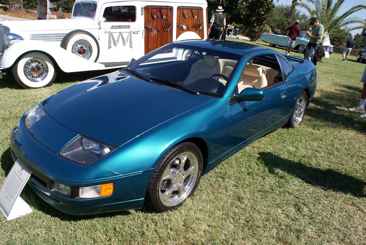 Front angle view of blue metallic sports coupe with pop-up headlights