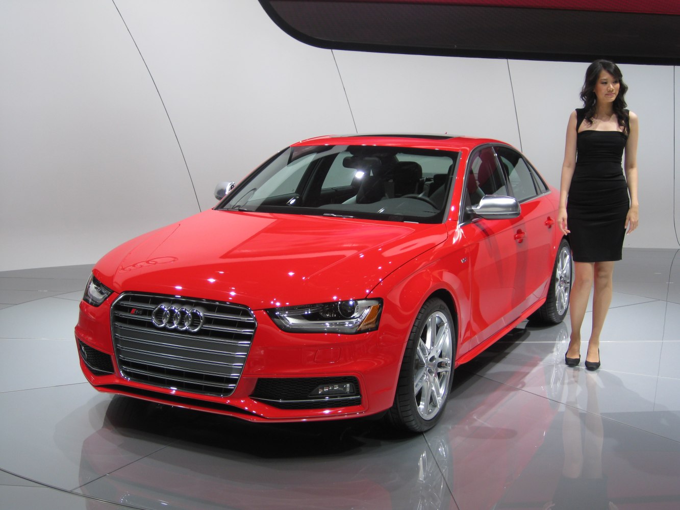 Red sedan with silver grille, alloy wheels, and sleek modern design.