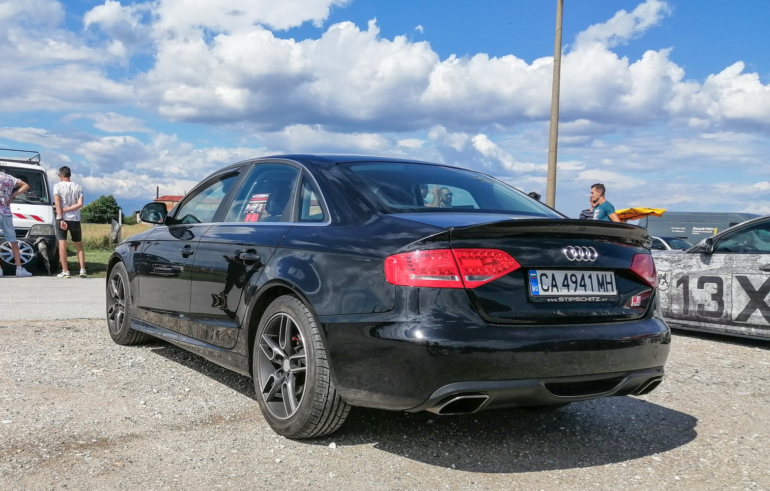 Rear view of sedan with black alloy wheels and dual exhaust tips
