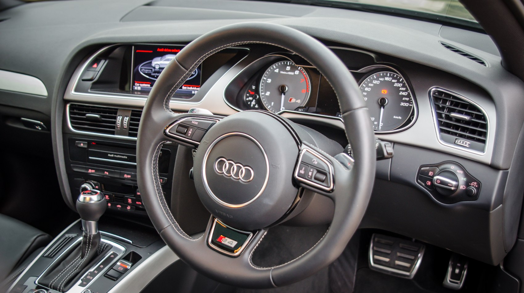 Steering wheel and dashboard with instrument cluster and center console.