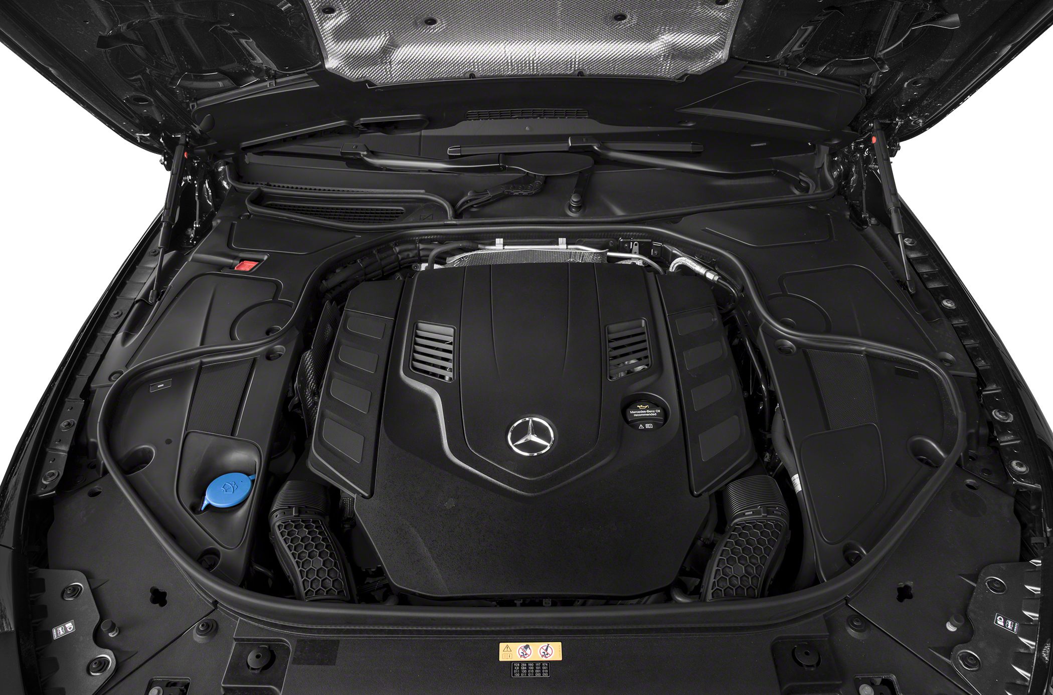Engine bay with large black engine cover and Mercedes-Benz emblem